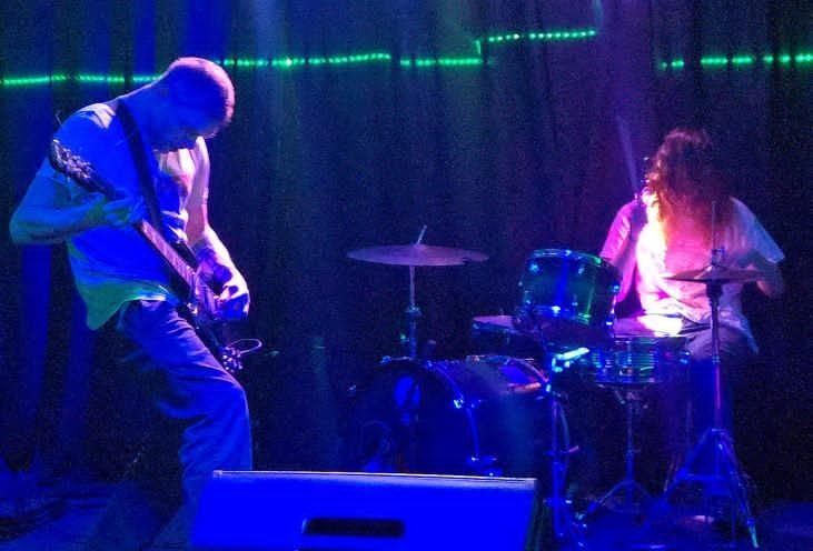 Wide shot of the duo under blue light