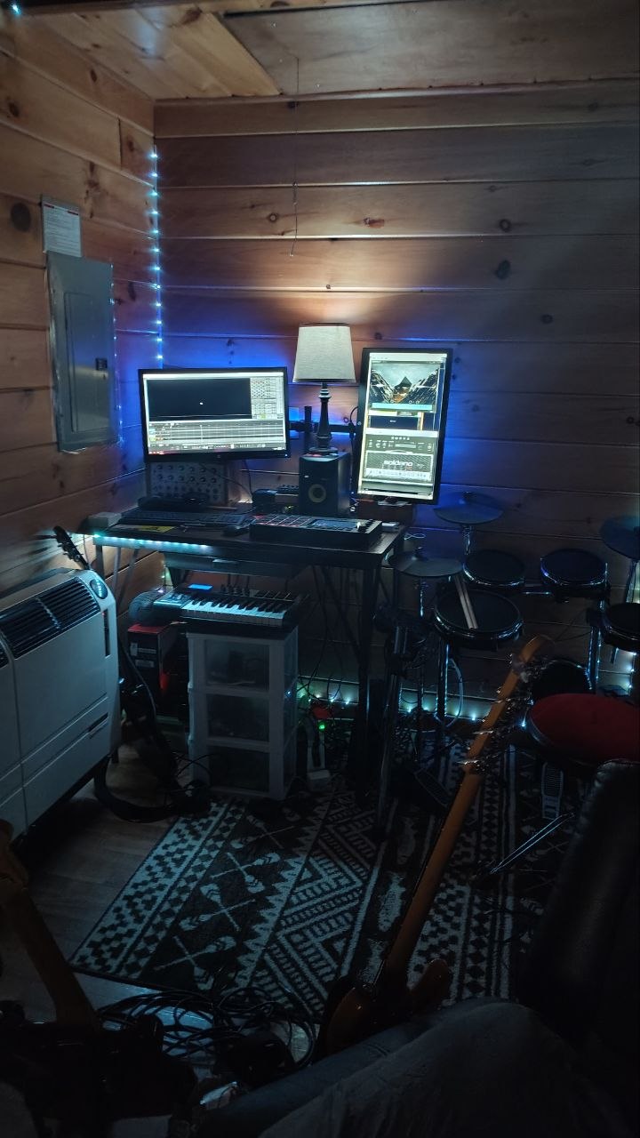 Home studio room with cabin walls, electronic drums, and monitors